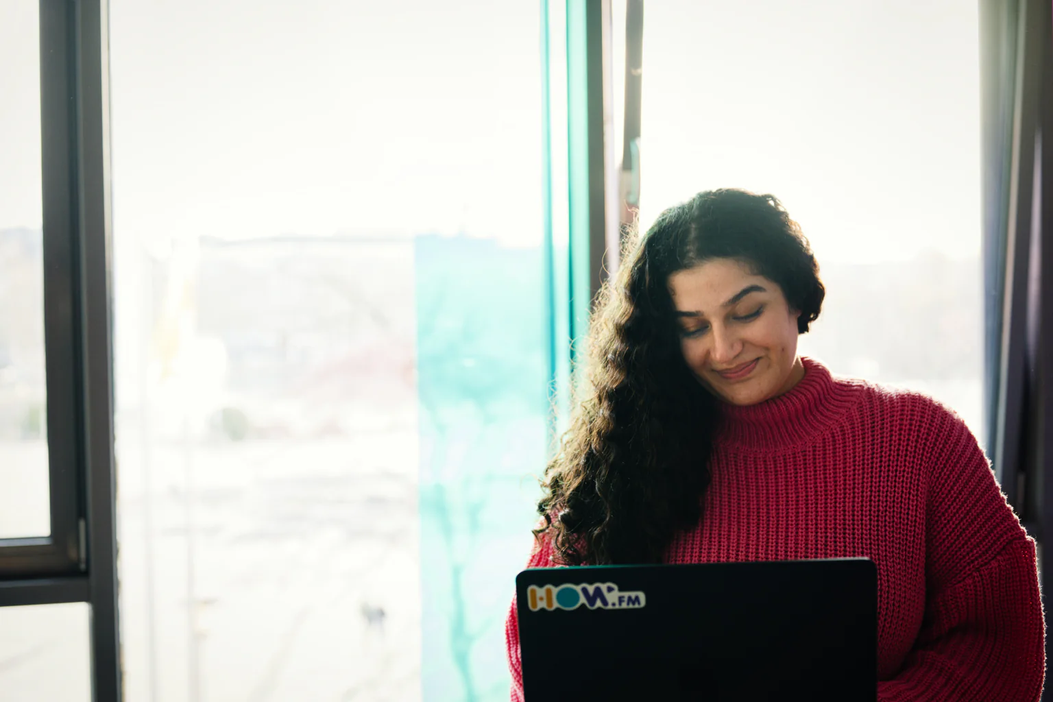 A how.fm team member working on a laptop in the Cologne office